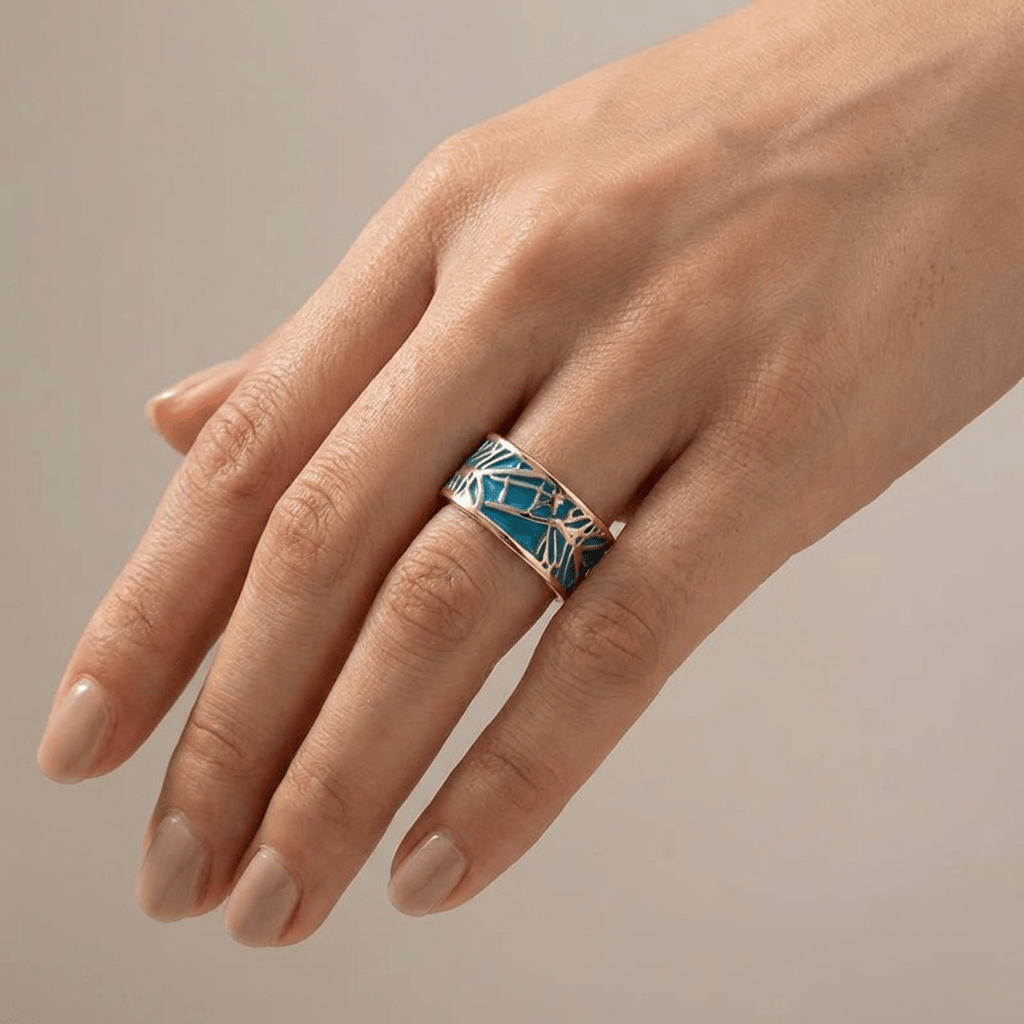 Anel de ouro rosé com pedra turquoise e design místico, da marca Rose & Oliver, exibido em close na imagem.
