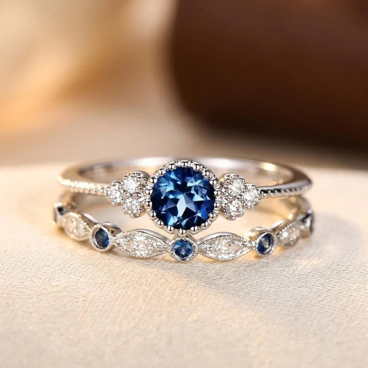 Anillo de plata con zafiro y halo de piedras brillantes, diseño elegante de la marca Rose & Oliver.