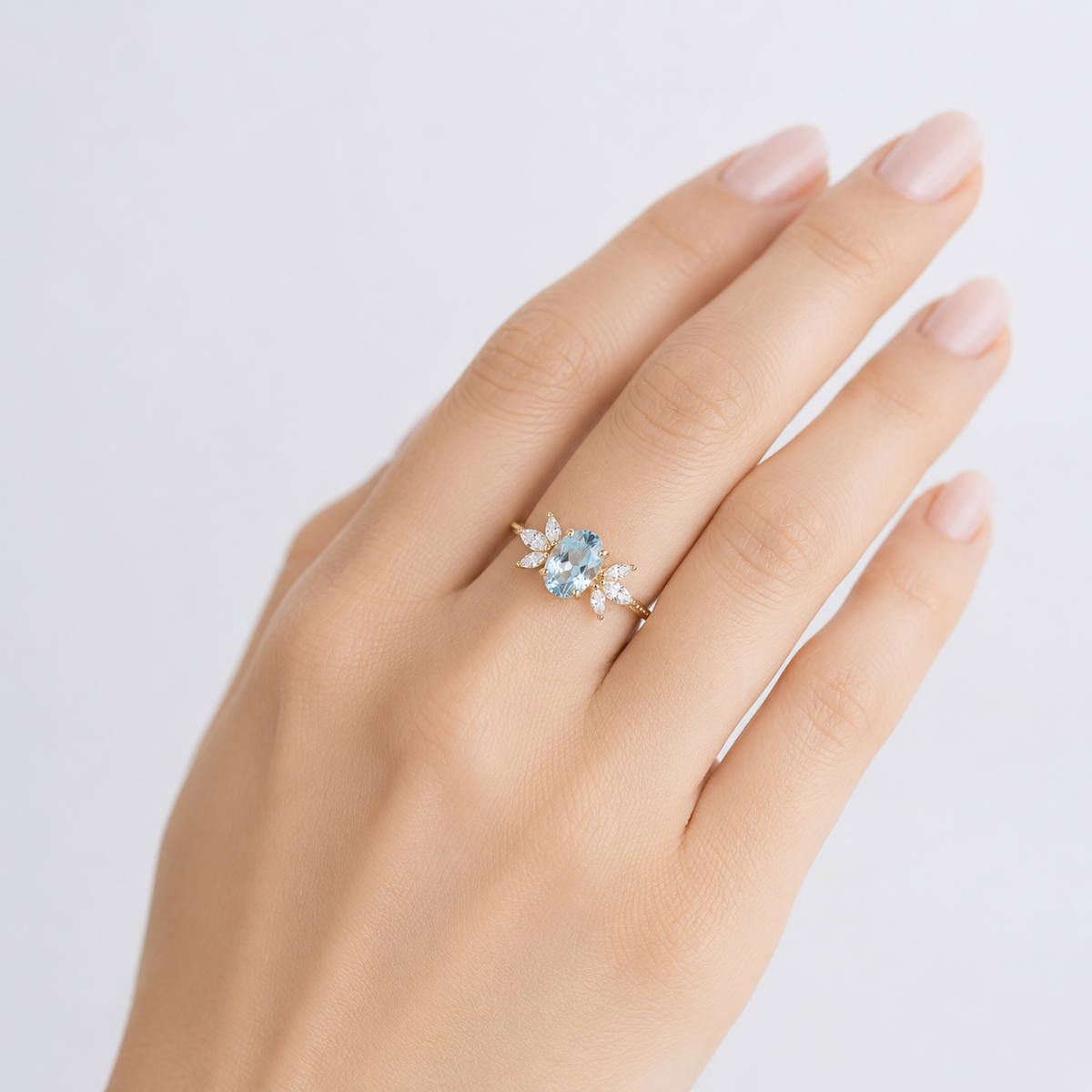 Goldener Ring mit glänzendem Marquise-Aquamarin-Stein, von der Marke Rose & Oliver, prominent im Bild dargestellt.