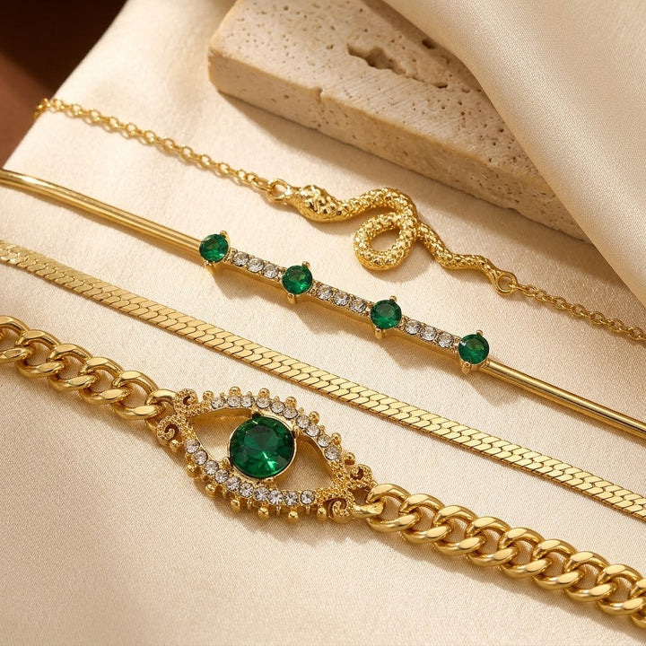 Pulseira de charme com esmeraldas douradas da Rose & Oliver, detalhes de elos e pingentes de ouro em uma composição elegante.