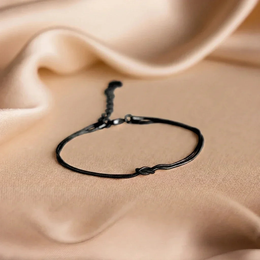 Pulseira Forever Knot da Rose & Oliver, símbolo de conexão e amizade, em acabamento preto, para casais, amigos e familiares.